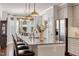 Bright kitchen with stainless steel refrigerator, granite countertop island, and elegant lighting fixtures at 714 Waterford Lake Dr, Cary, NC 27519