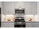 Well-equipped kitchen with stainless steel appliances, granite counters, and bright white cabinets and tile backsplash at 714 Waterford Lake Dr, Cary, NC 27519