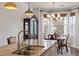 Kitchen island with double sink, stainless steel faucet, granite countertops, and adjacent dining area at 714 Waterford Lake Dr, Cary, NC 27519