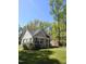 Quaint cottage-style home with a charming front porch surrounded by lush greenery on a sunny day at 8 Elaine Cir, Durham, NC 27703