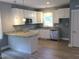 Bright and modern kitchen features white cabinets, stainless steel appliances, and granite counters at 8 Elaine Cir, Durham, NC 27703