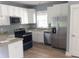 Modern kitchen with stainless steel appliances, white cabinets, and granite countertops at 8 Elaine Cir, Durham, NC 27703