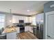 Modern kitchen showcasing white cabinetry, stainless steel appliances, and a granite-topped island with bar seating at 8 Elaine Cir, Durham, NC 27703