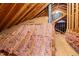Unfinished attic with exposed insulation, wood framing, and a chimney, showing potential for expansion at 8116 Windsor Ridge Dr, Raleigh, NC 27615