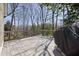 View of a spacious back deck with a gray stain and a grill, surrounded by trees offering shade and privacy at 8116 Windsor Ridge Dr, Raleigh, NC 27615