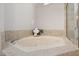A relaxing soaking tub with tiled surround and decorative accents at 8116 Windsor Ridge Dr, Raleigh, NC 27615