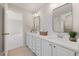 Bright bathroom featuring dual sinks, modern fixtures, white cabinets and quartz countertops, and mirrors at 8116 Windsor Ridge Dr, Raleigh, NC 27615