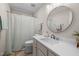 Neutral bathroom with rounded mirror, white shower curtain, and vanity at 8116 Windsor Ridge Dr, Raleigh, NC 27615