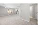 Large bonus room featuring a wet bar, neutral walls and carpet, with a ceiling fan, and a staircase entrance at 8116 Windsor Ridge Dr, Raleigh, NC 27615