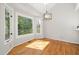 Dining room with hardwood floors, large windows, and modern light fixture at 8116 Windsor Ridge Dr, Raleigh, NC 27615