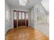 Foyer with hardwood floors, a decorative wood door, and an entry to the spacious living room at 8116 Windsor Ridge Dr, Raleigh, NC 27615
