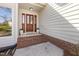 Covered brick front porch with a stained wood and glass door and classic white planters at 8116 Windsor Ridge Dr, Raleigh, NC 27615