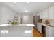 Bright kitchen features white cabinets, stainless steel appliances, and a wine cooler at 8116 Windsor Ridge Dr, Raleigh, NC 27615