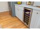 Close up of a wine cooler built into the kitchen cabinetry with hardwood floors at 8116 Windsor Ridge Dr, Raleigh, NC 27615