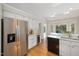 Spacious white kitchen features stainless steel appliances and a wine refrigerator, perfect for entertaining at 8116 Windsor Ridge Dr, Raleigh, NC 27615