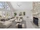 Bright living room features a stone fireplace, a ceiling fan and a large window allowing for plenty of natural light at 8116 Windsor Ridge Dr, Raleigh, NC 27615