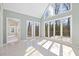 Inviting sunroom with tiled floors and lots of natural light from the surrounding windows at 8116 Windsor Ridge Dr, Raleigh, NC 27615