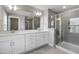 Bright bathroom featuring double vanity with white cabinetry, large mirror, and walk-in shower with glass door at 8729 Maxine St # 38, Willow Springs, NC 27592