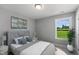 Bright bedroom featuring a large window with backyard view, a comfy bed, and stylish decor at 8729 Maxine St # 38, Willow Springs, NC 27592