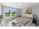 Cozy bedroom showcasing a large window with backyard views, neutral tones and a queen size bed at 8729 Maxine St # 38, Willow Springs, NC 27592