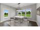 Inviting dining room with modern light fixture, gray chairs, and a view of the backyard at 8729 Maxine St # 38, Willow Springs, NC 27592