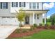 Charming home exterior showcasing a well-manicured lawn, mulch flower beds, and a covered front door entrance at 8729 Maxine St # 38, Willow Springs, NC 27592