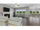 Bright living room with fireplace, large windows, stylish seating, and hardwood floors in neutral tones at 8729 Maxine St # 38, Willow Springs, NC 27592
