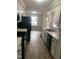 Well-lit kitchen featuring white cabinets, black appliances, and wood-look flooring at 912 Pamela Ln, Rocky Mount, NC 27803
