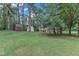 Spacious backyard with mature trees, lush lawn, and outbuildings at 913 Ranch Farm Rd, Raleigh, NC 27603
