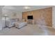 Cozy living room featuring a brick accent wall, neutral-colored sofa and soft carpeting at 913 Ranch Farm Rd, Raleigh, NC 27603
