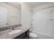 Well-lit bathroom boasts a granite countertop, dark cabinetry, and a shower-tub combination at 1003 Mirbeck Ln, Durham, NC 27713