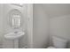 Powder room featuring a pedestal sink, a round mirror, and a toilet at 1003 Mirbeck Ln, Durham, NC 27713