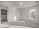 Spacious bedroom with neutral walls, carpet, window with blinds, and a door to the hallway at 1003 Mirbeck Ln, Durham, NC 27713