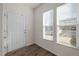 Inviting foyer featuring wood-look flooring, a white door, and bright windows with blinds at 1003 Mirbeck Ln, Durham, NC 27713