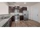 Kitchen features stainless steel appliances, dark wood cabinets, granite countertops, and wood flooring at 1003 Mirbeck Ln, Durham, NC 27713