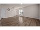 Bright living area with wood-look flooring, white walls, and a window offering natural light at 1003 Mirbeck Ln, Durham, NC 27713