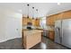 Kitchen features stainless appliances, wood cabinets, and an island with granite countertop at 101 Palmwood Ct, Cary, NC 27519