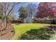 Large backyard with lush green grass, mature trees, privacy fence and detached shed at 1010 Rosehill Ave, Durham, NC 27705