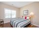 Cozy bedroom with hardwood floors, a striped comforter, and natural light from the window at 1013 Restoration Dr, Durham, NC 27703