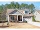 Attractive home with stone accents, shingle siding, a well-manicured lawn, and an attached garage at 1013 Restoration Dr, Durham, NC 27703