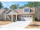 Inviting home showcasing stone and shingle siding, a covered entry, and a convenient attached garage at 1013 Restoration Dr, Durham, NC 27703