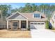 Charming home featuring stone and shingle siding, a covered porch, and an attached garage at 1013 Restoration Dr, Durham, NC 27703