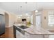 A kitchen island features a stainless steel sink and granite countertops, with a view to the living room at 1013 Restoration Dr, Durham, NC 27703