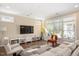 Well-lit living room with neutral colors, large windows, and access to an outdoor patio at 1013 Restoration Dr, Durham, NC 27703