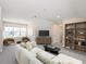 Spacious living room with large windows, plush seating, built in shelves, and modern decor at 1013 Restoration Dr, Durham, NC 27703