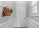 Cozy entryway with a white door, coat hooks, and decorative wreath, offering a welcoming first impression at 104 Stenness Ct, Apex, NC 27502