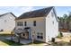 Back exterior featuring a covered patio, grassy lawn, and neutral siding, designed for outdoor living and relaxation at 104 Vinewood Pl, Holly Springs, NC 27540