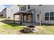 Landscaped backyard featuring a stone firepit and covered gazebo, perfect for outdoor entertaining and relaxation at 104 Vinewood Pl, Holly Springs, NC 27540