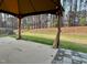 A covered outdoor patio with adjacent lawn, providing a serene space for relaxation and enjoying the natural surroundings at 104 Vinewood Pl, Holly Springs, NC 27540