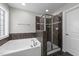 Modern bathroom featuring a tiled shower, soaking tub, and tiled flooring at 104 Vinewood Pl, Holly Springs, NC 27540